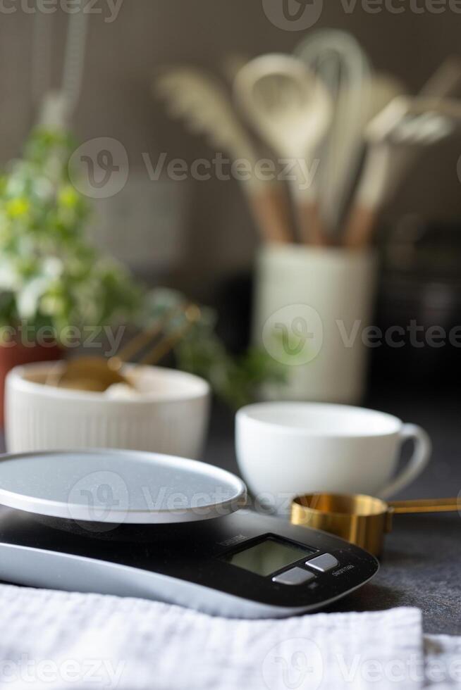 Scales, bowl, measuring spoon, napkin, cup on table. Empty space for product photo
