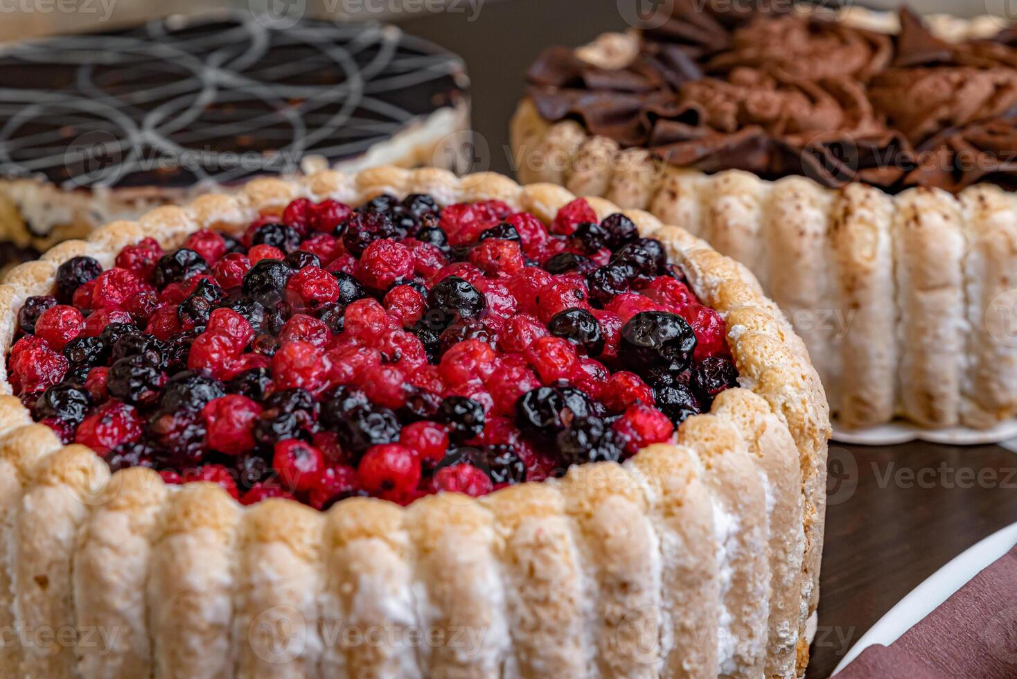 Assorted fresh cakes on a dark table photo