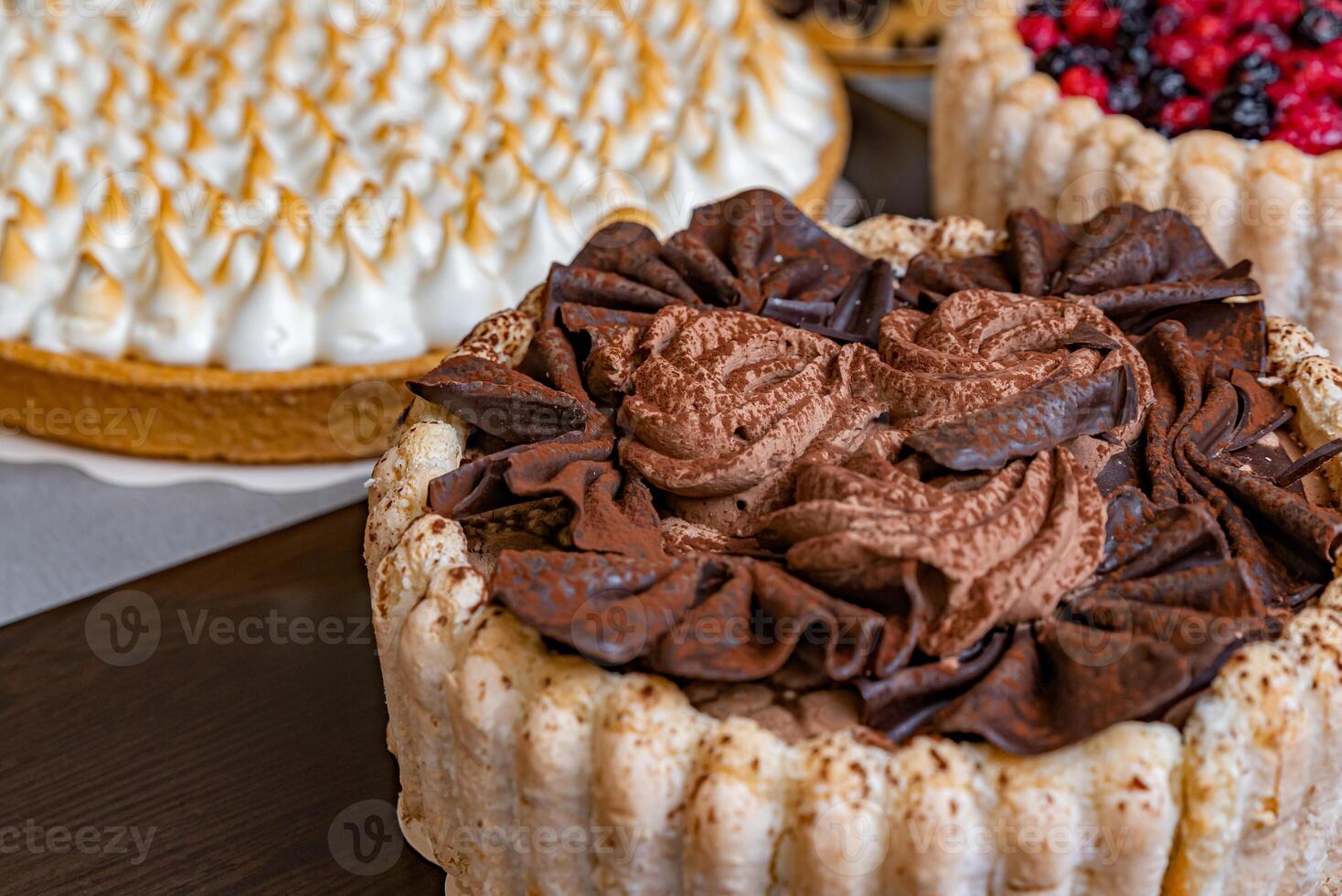 Assorted fresh cakes on a dark table photo