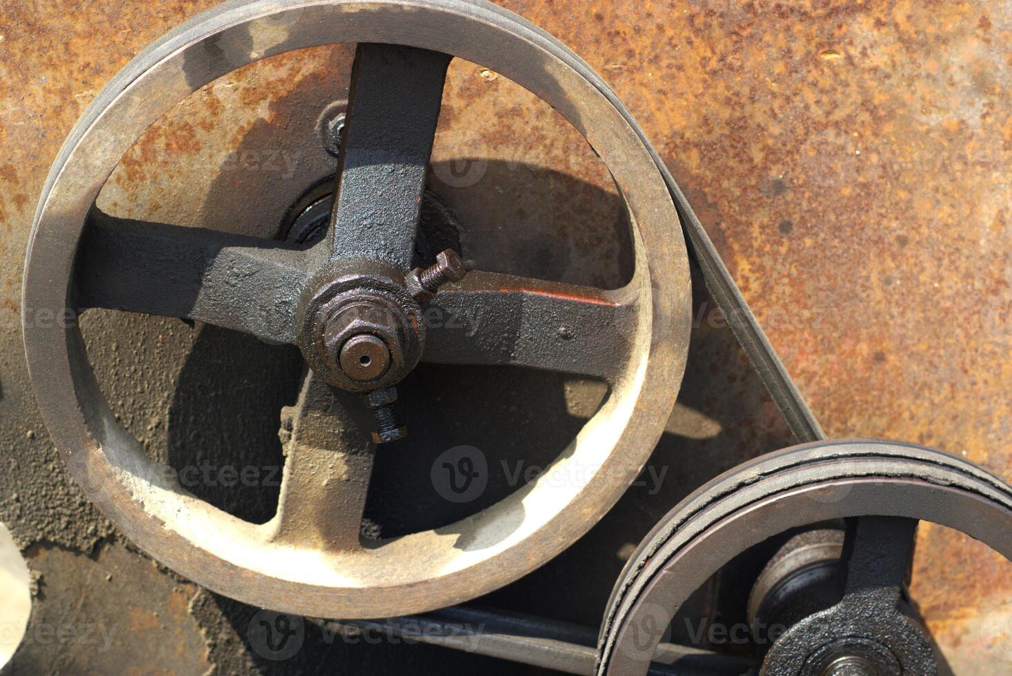 close up of a wheel gear with belt on a rusty metal background, mechanical engineering photo