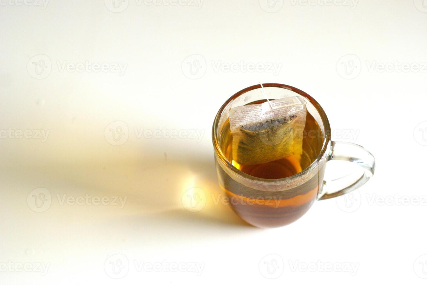 A cup of tea with tea bag on white background with copy space area, hot drink for breakfast photo