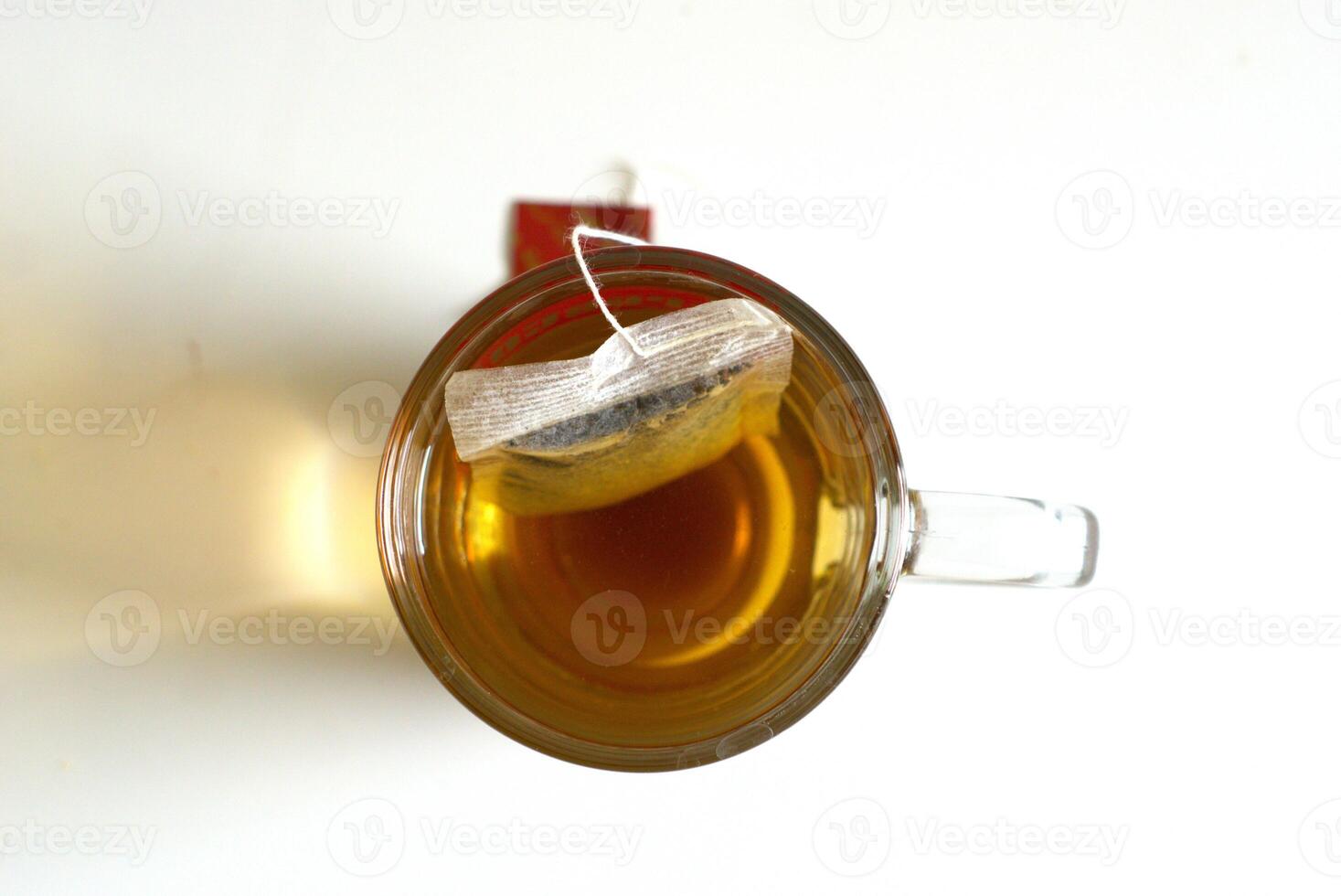 Top view of a cup of tea with tea bag on white background, hot drink for breakfast photo