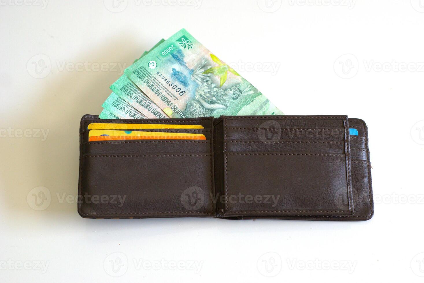Leather wallet with bank card and Indonesian rupiah banknotes, Twenty thousand rupiah in wallet isolated on white background photo