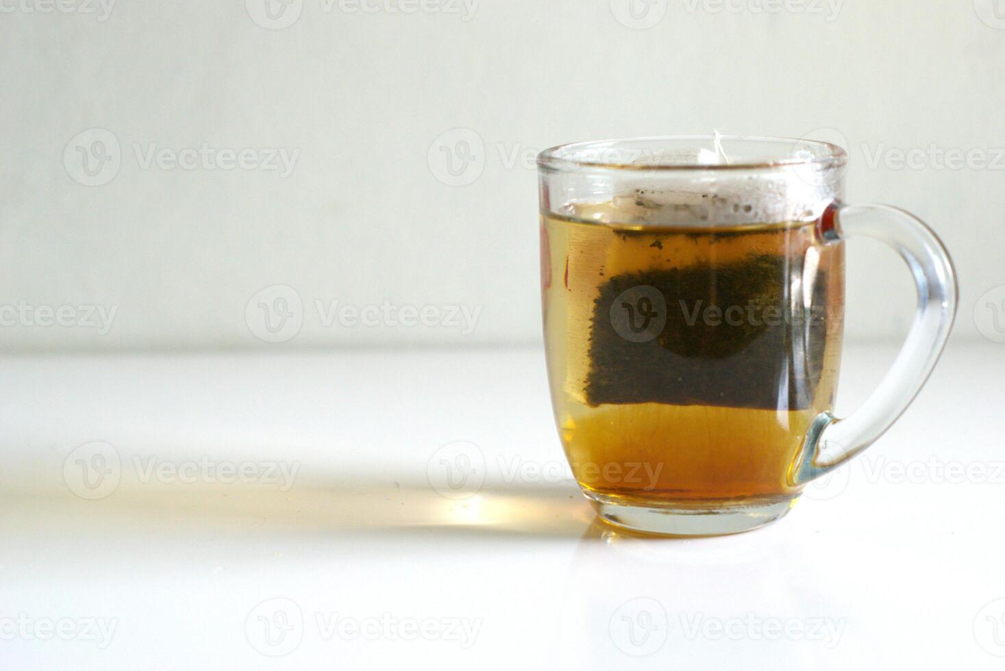 A cup of tea with tea bag on white background with copy space area, hot drink for breakfast photo