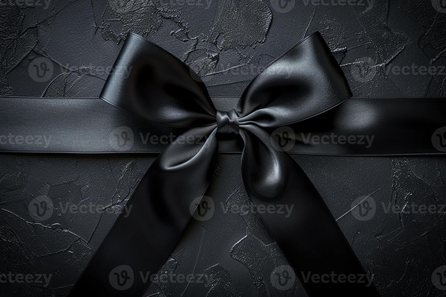 Top view of black satin ribbon bow on dark background. Gothic design element. photo