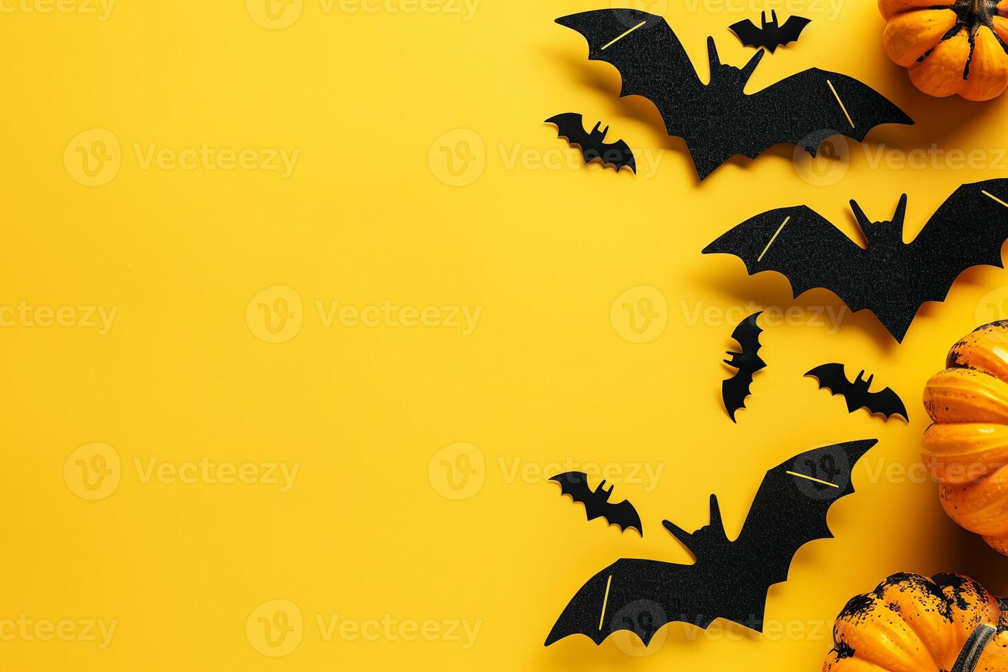Minimalistic Halloween flat lay with black bats and orange pumpkins on white background photo
