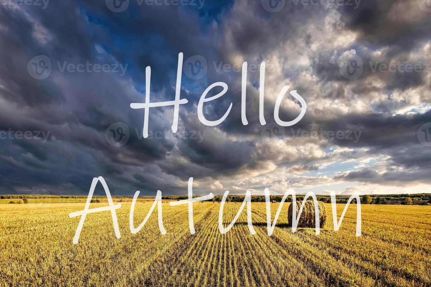 The words Hello Autumn on the background of field with golden haystacks. Greeting card. The concept of the beginning of autumn. photo