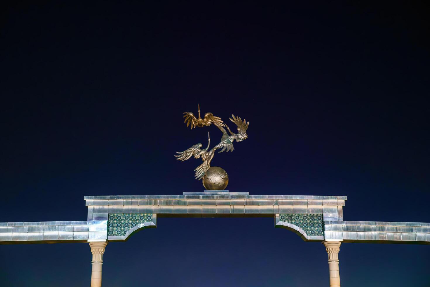 Tashkent, Uzbekistan - August 12, 2023 Memorial of Independence with illumination in the Independence Square at summertime in nighttime. photo