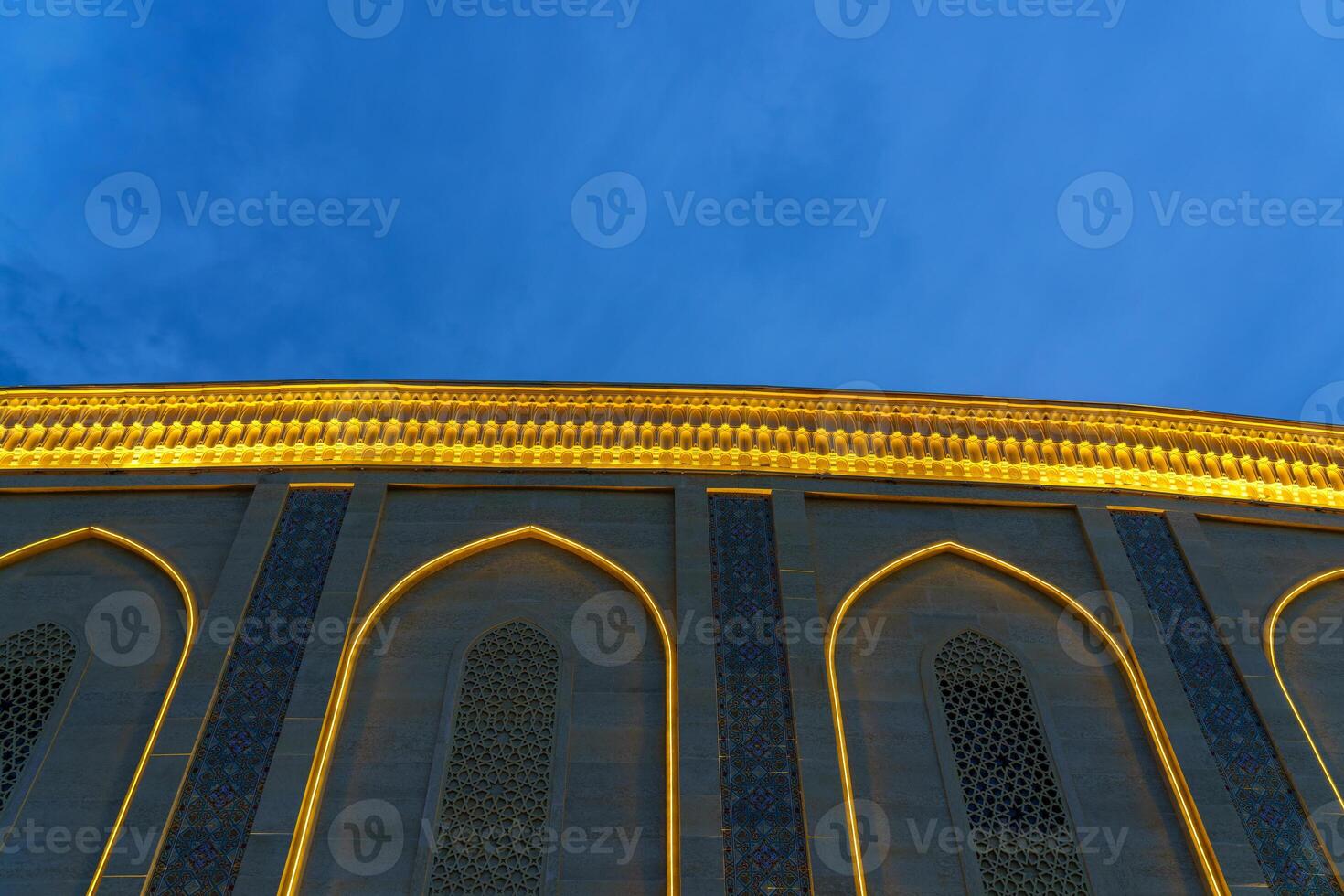 A fragment of an oriental building decorated with garlands and ornaments against the background of the night sky. photo