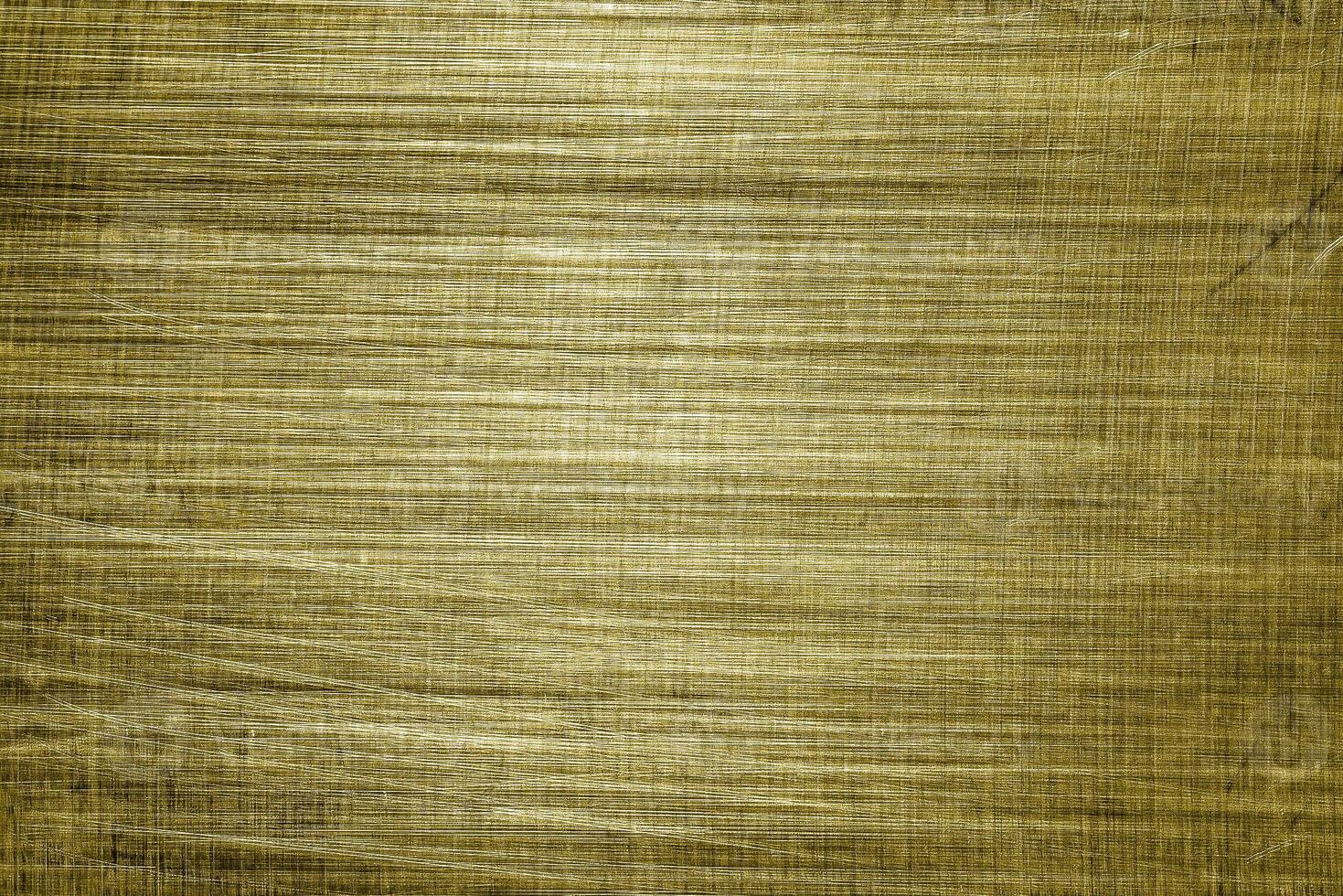 Golden texture of shiny scratched metal. Abstract gold background. photo