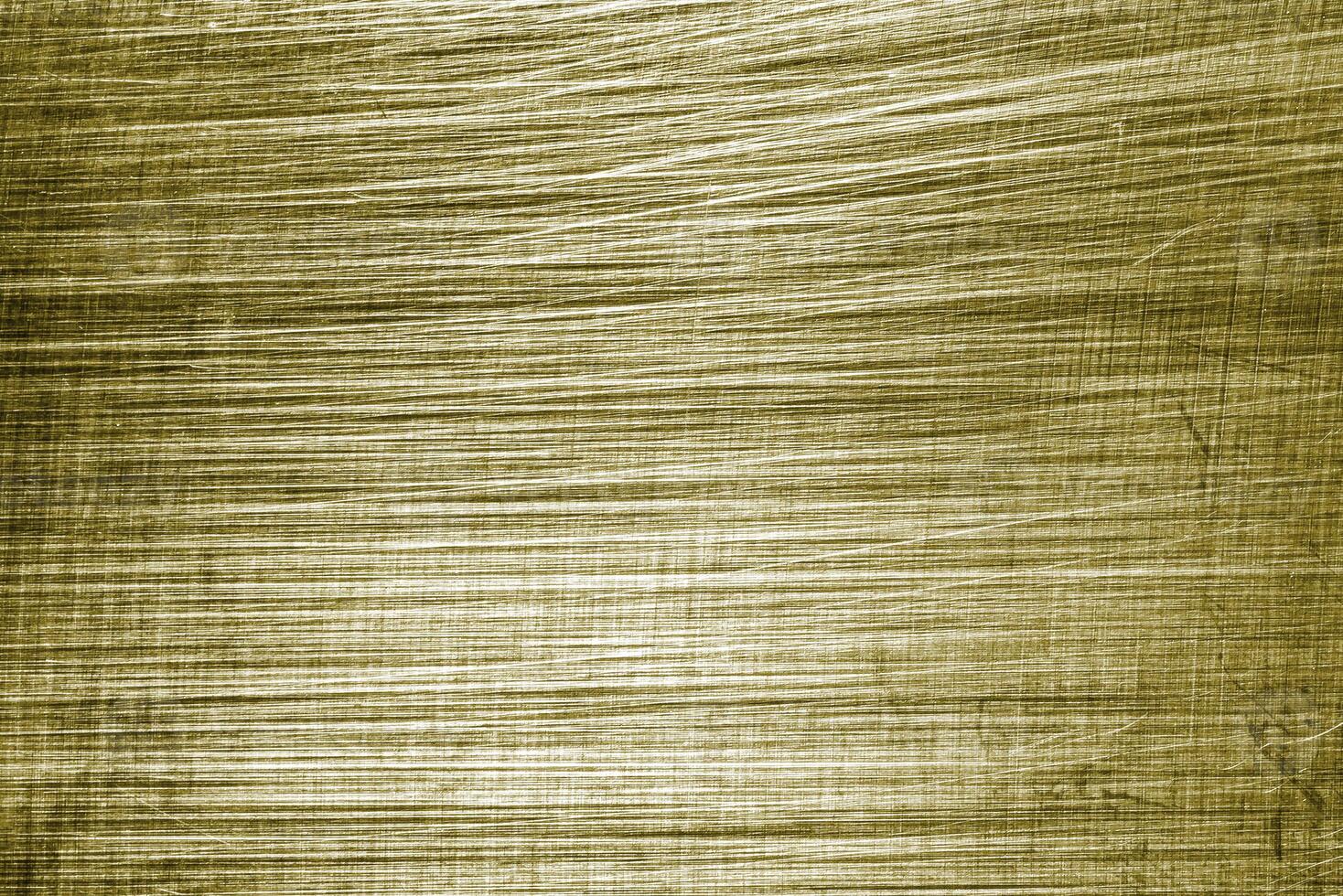 Golden texture of shiny scratched metal. Abstract gold background. photo