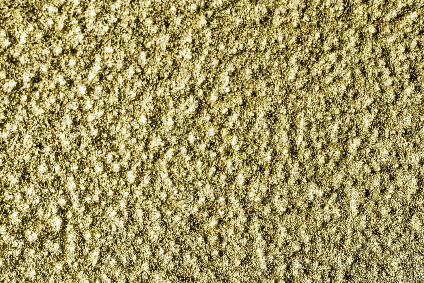 Golden texture of shiny grained metal. Abstract gold background. photo