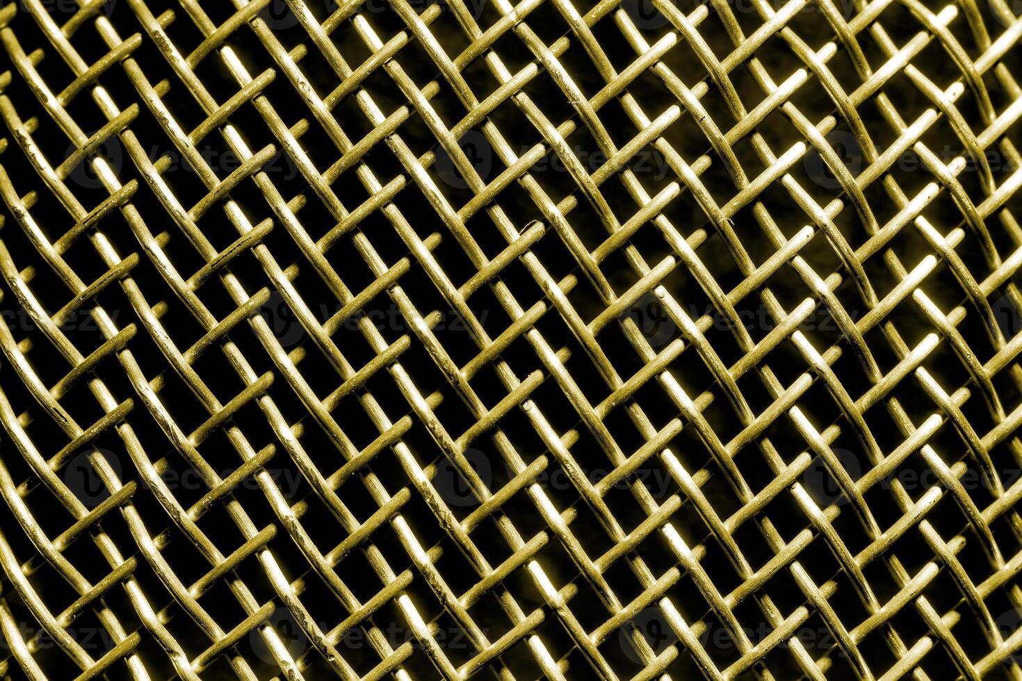 Golden texture of a shiny metal colander or grate. Abstract gold background. photo
