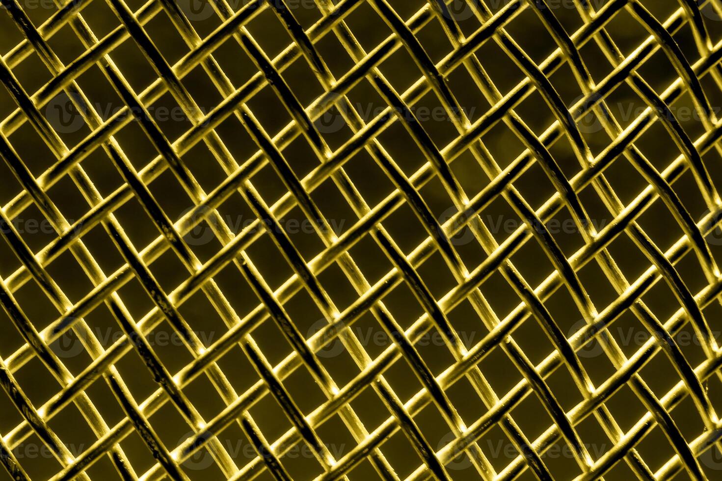 Golden texture of a shiny metal colander or grate. Abstract gold background. photo