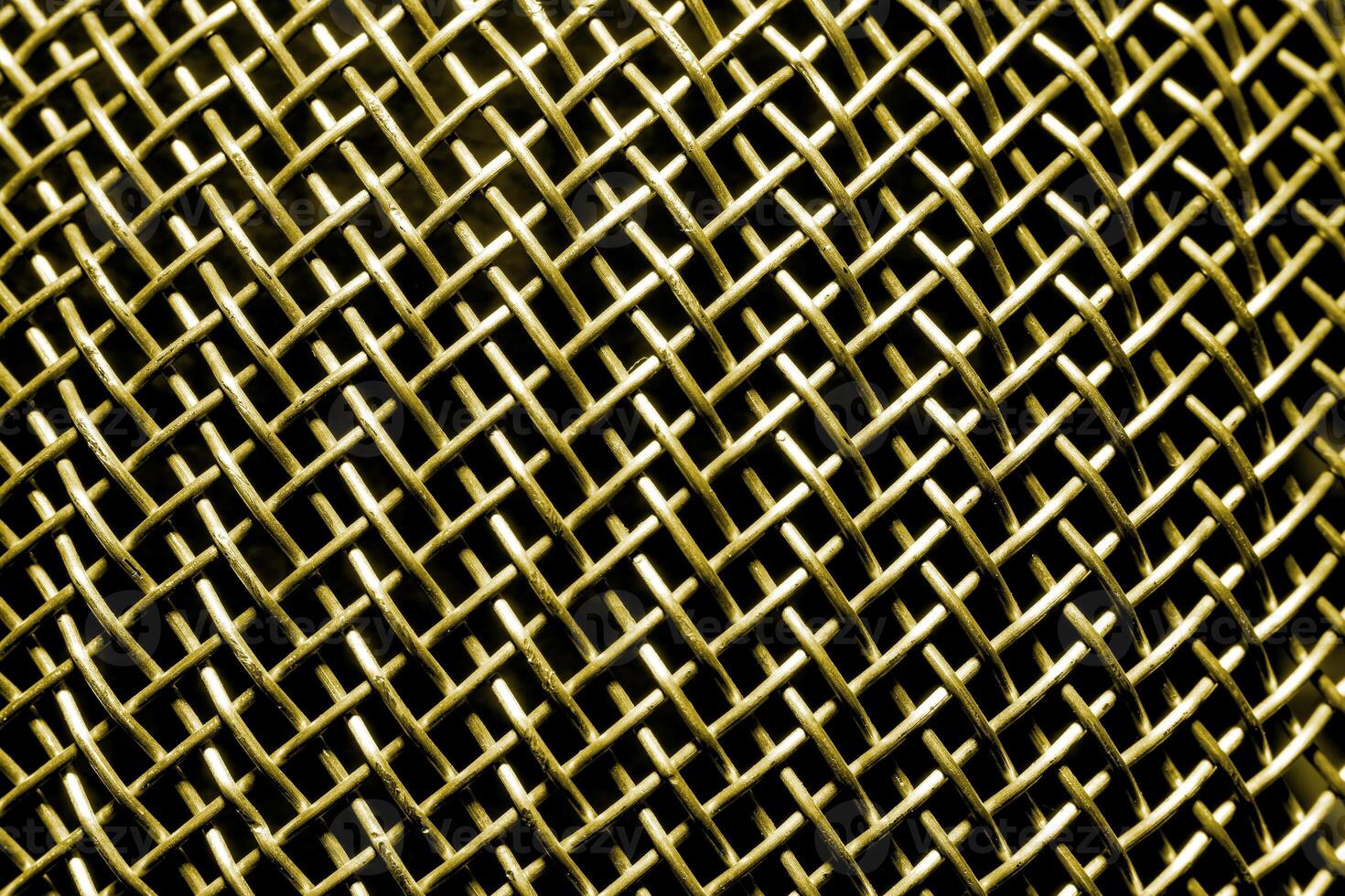Golden texture of a shiny metal colander or grate. Abstract gold background. photo