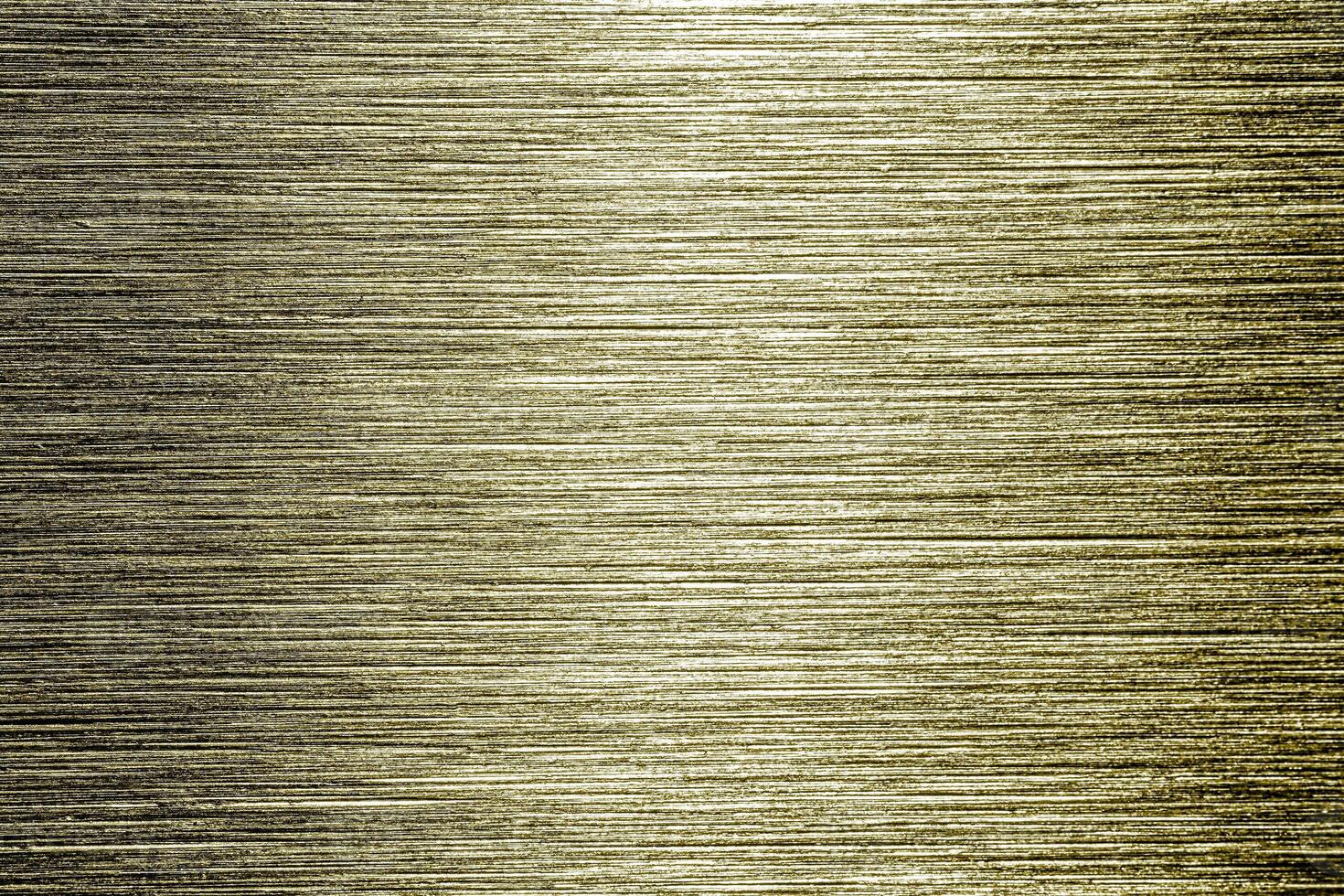 Golden texture of shiny scratched metal. Abstract gold background. photo