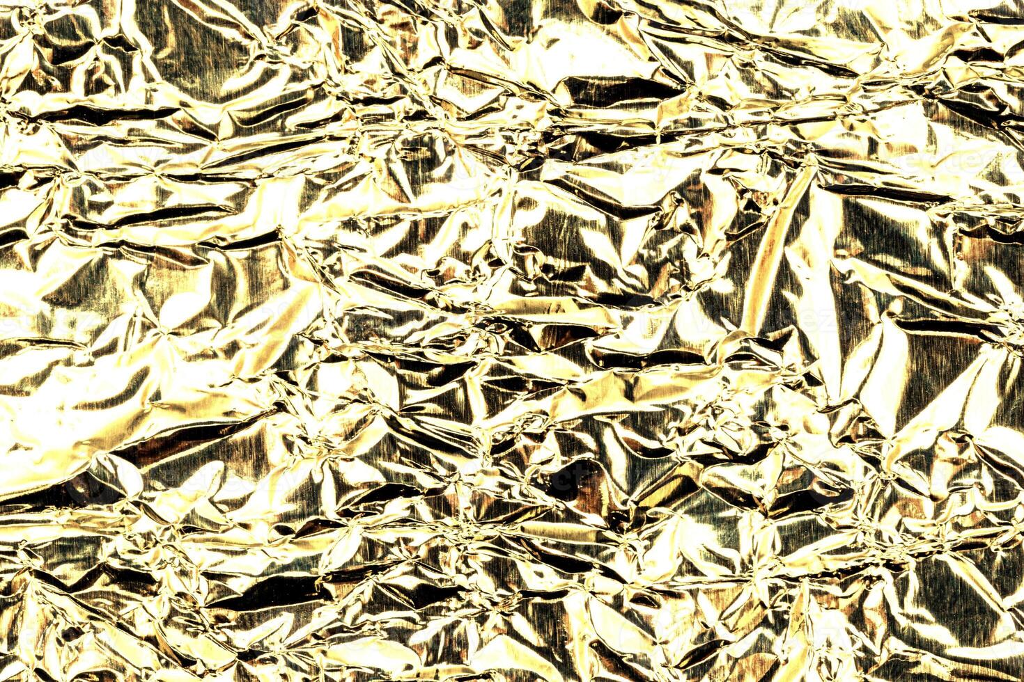 Texture of crumpled golden foil. Gold abstract blackground. photo