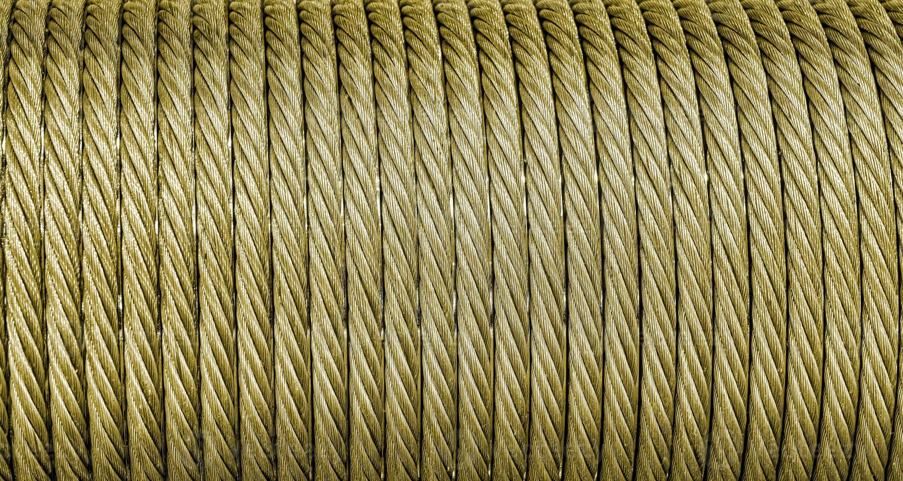 The texture of a new golden color cable wrapped in a spool. Abstract background. photo