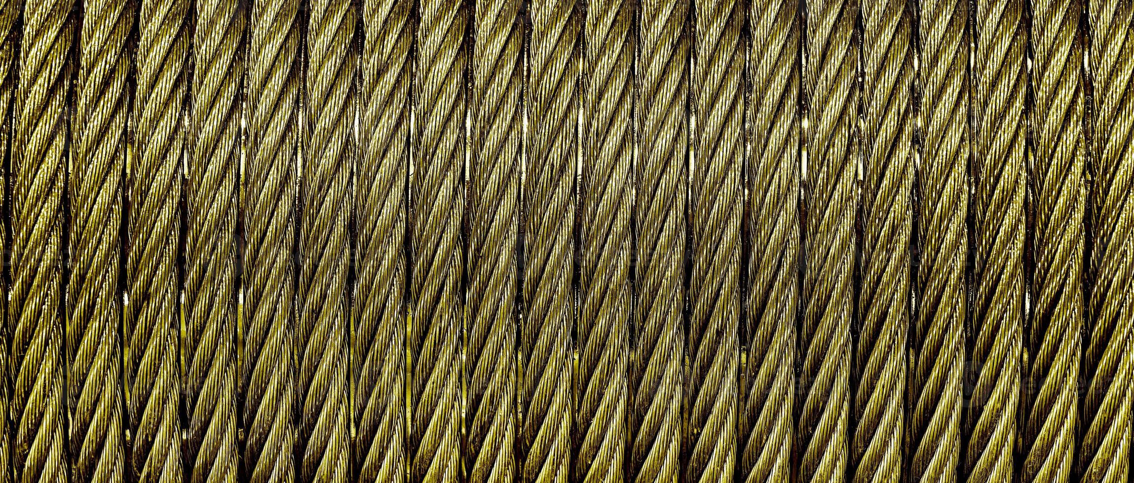 The texture of a new golden color cable wrapped in a spool. Abstract background. photo