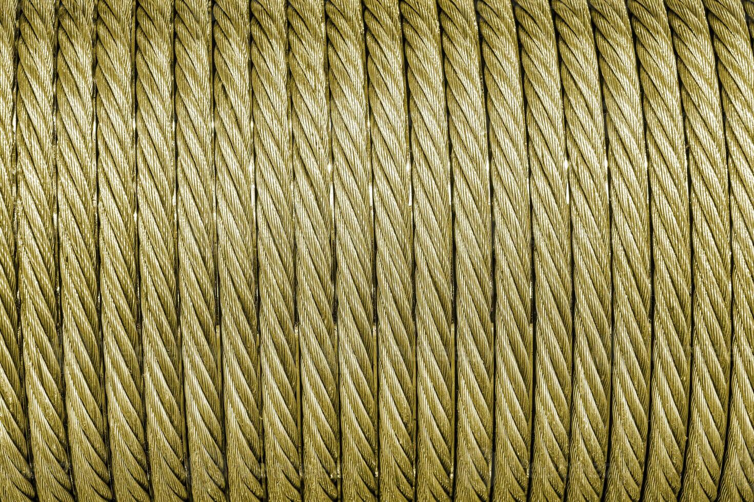 The texture of a new golden color cable wrapped in a spool. Abstract background. photo