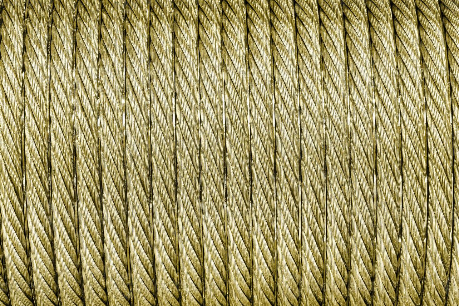 The texture of a new golden color cable wrapped in a spool. Abstract background. photo