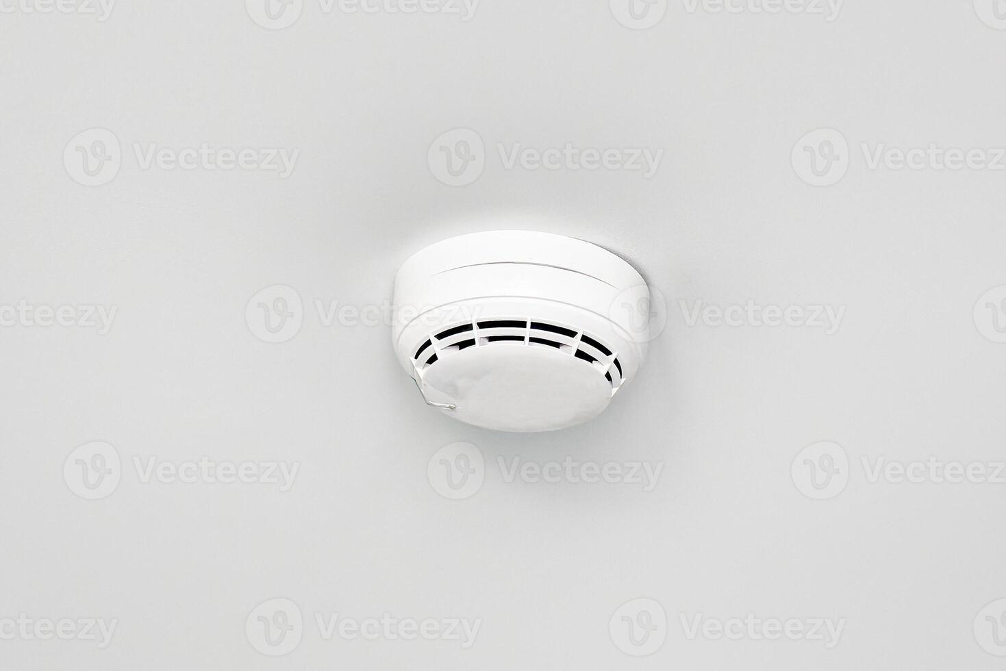 Smoke detector or fire alarm sensor on the ceiling. photo