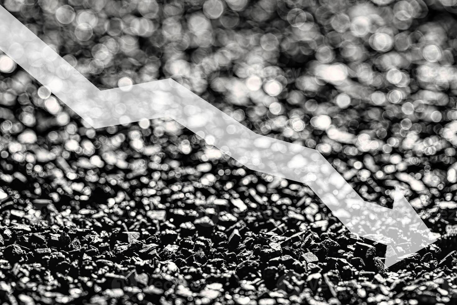 Arrow down on coal background. The concept of falling prices, mining, import, export, production or sales of coal. photo