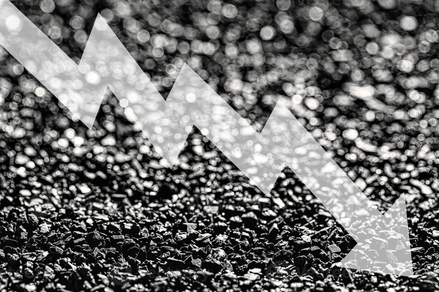 Arrow down on coal background. The concept of falling prices, mining, import, export, production or sales of coal. photo