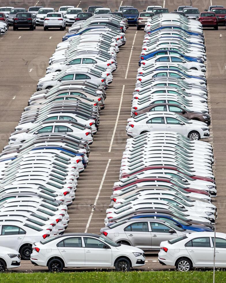 Rows of a new cars parked in a distribution center of a car factory. photo