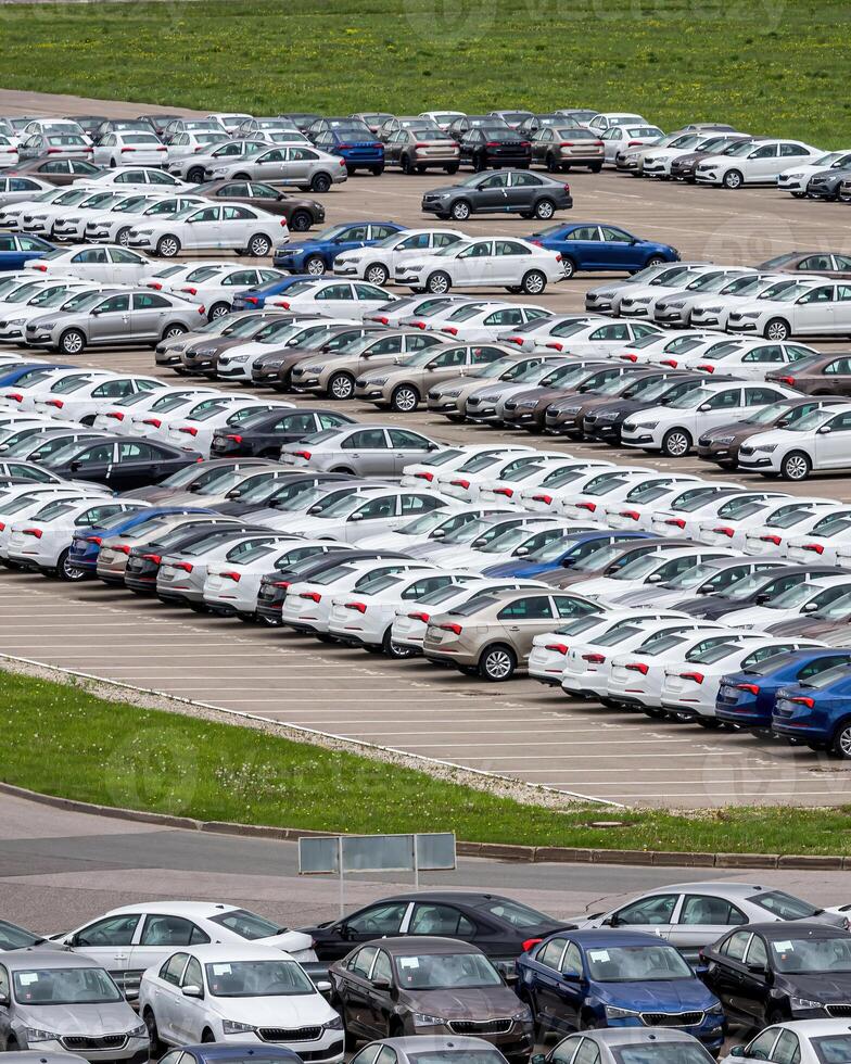 Rows of a new cars parked in a distribution center of a car factory. photo
