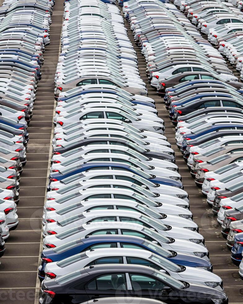 Rows of a new cars parked in a distribution center of a car factory. photo