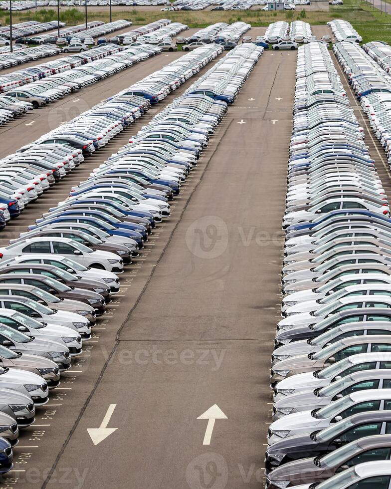 Rows of a new cars parked in a distribution center of a car factory. photo