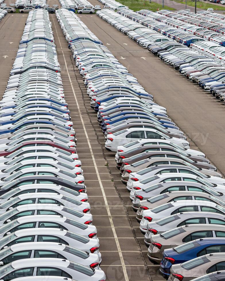 Rows of a new cars parked in a distribution center of a car factory. photo