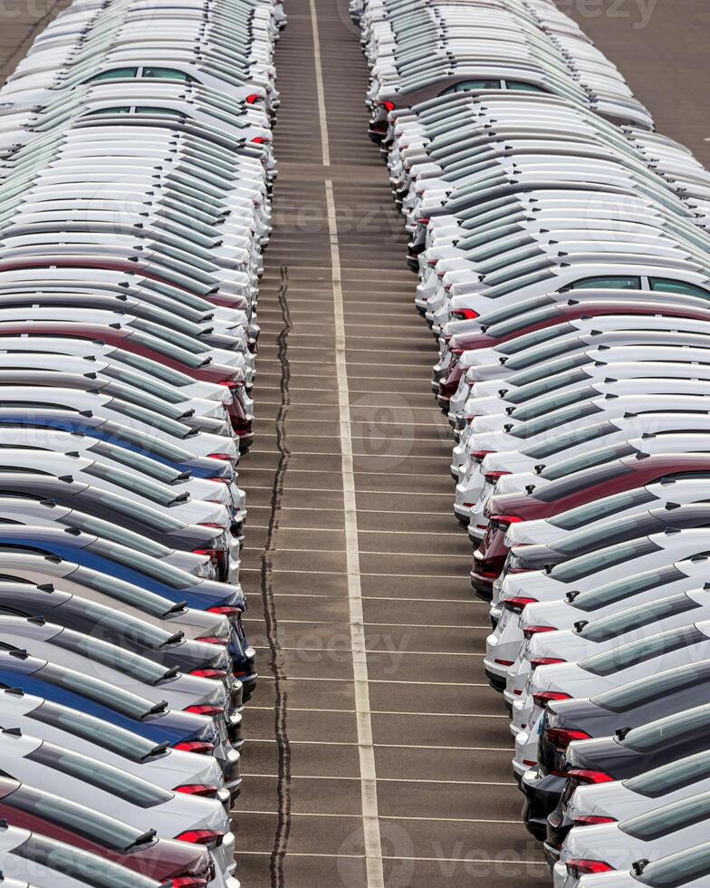 Rows of a new cars parked in a distribution center of a car factory. photo