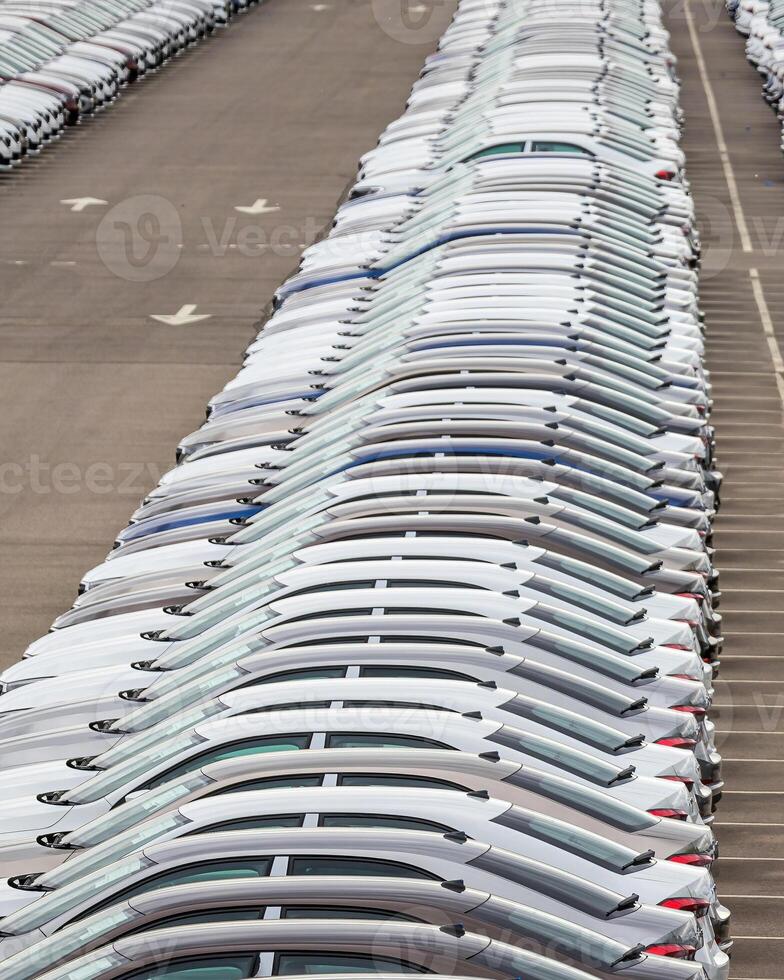 Rows of a new cars parked in a distribution center of a car factory. photo
