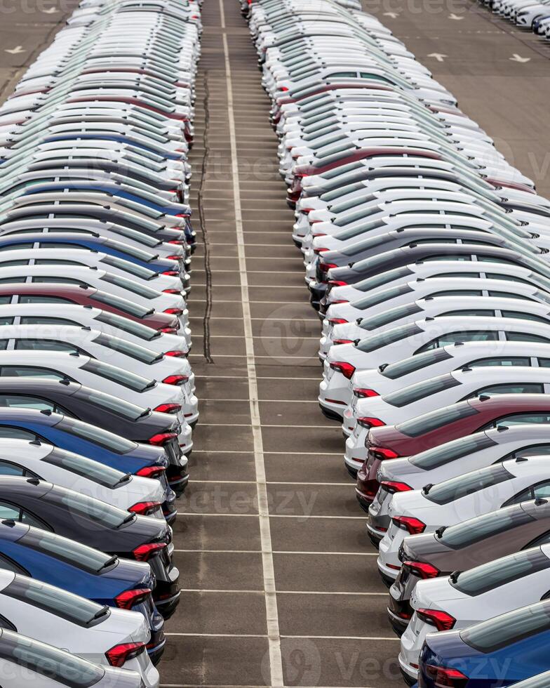 Rows of a new cars parked in a distribution center of a car factory. photo