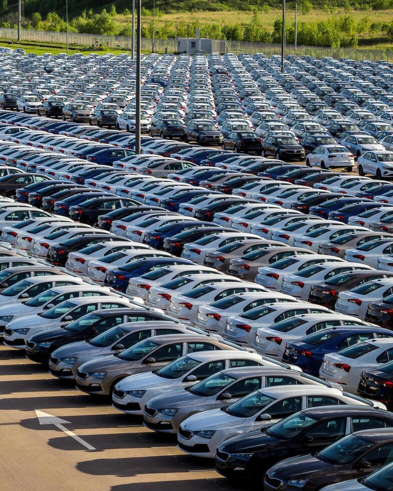 Volkswagen Group Rus, Russia, Kaluga - MAY 25, 2020 Rows of a new cars parked in a distribution center on a sunny day in the sprin. photo