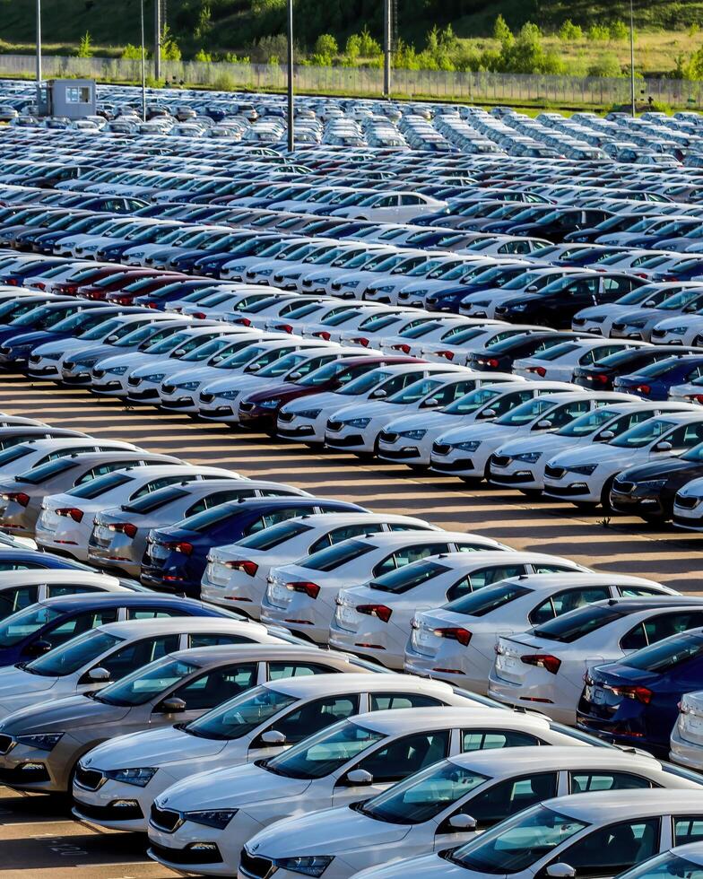 Volkswagen Group Rus, Russia, Kaluga - MAY 25, 2020 Rows of a new cars parked in a distribution center on a sunny day in the sprin. photo