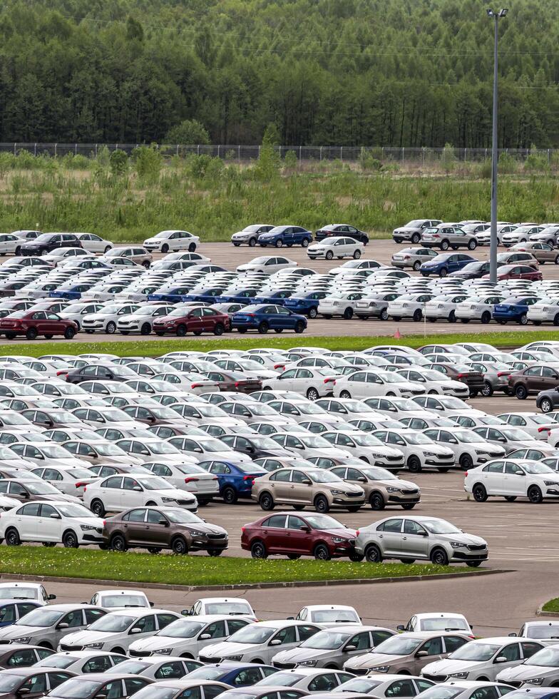 Volkswagen Group Rus, Russia, Kaluga - MAY 24, 2020 Rows of a new cars parked in a distribution center on a cloudy day in the spring, a car factory photo