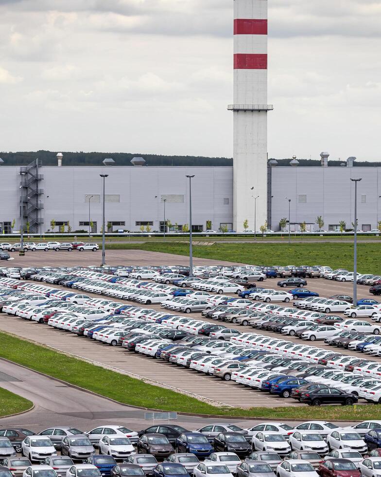 Volkswagen Group Rus, Russia, Kaluga - MAY 24, 2020 Rows of a new cars parked in a distribution center on a cloudy day in the spring, a car factory photo