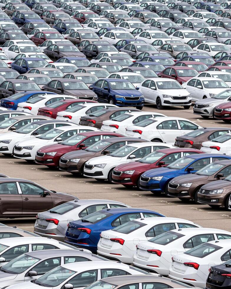 Volkswagen Group Rus, Russia, Kaluga - MAY 24, 2020 Rows of a new cars parked in a distribution center on a cloudy day in the spring, a car factory photo
