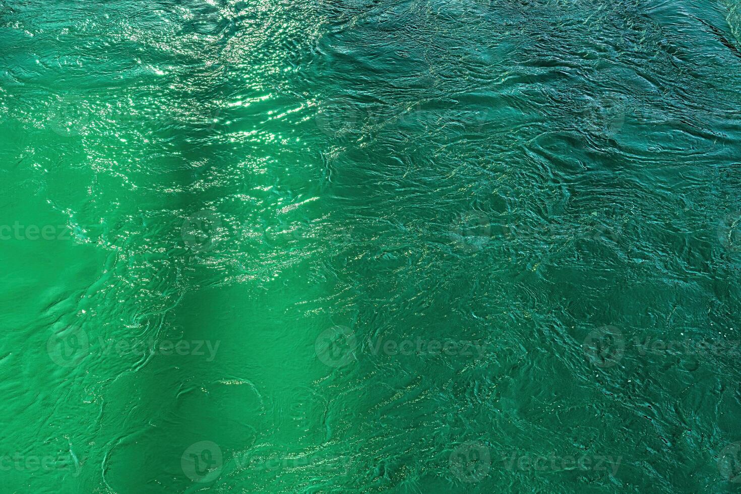 The texture of the waves of turquoise color of fast-flowing water in the river. photo