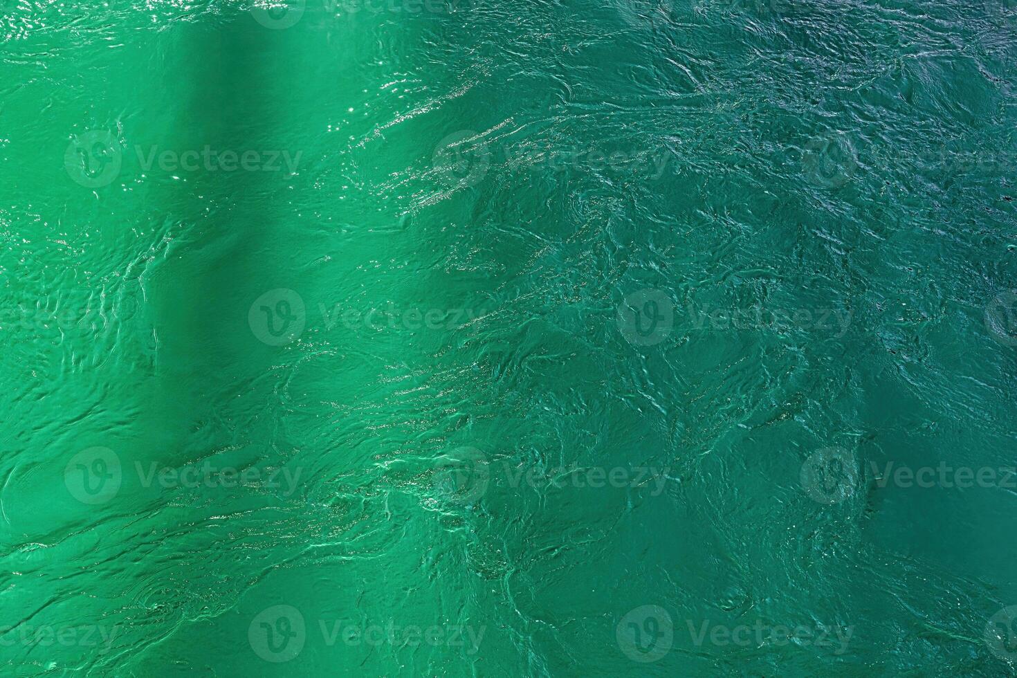 The texture of the waves of turquoise color of fast-flowing water in the river. photo