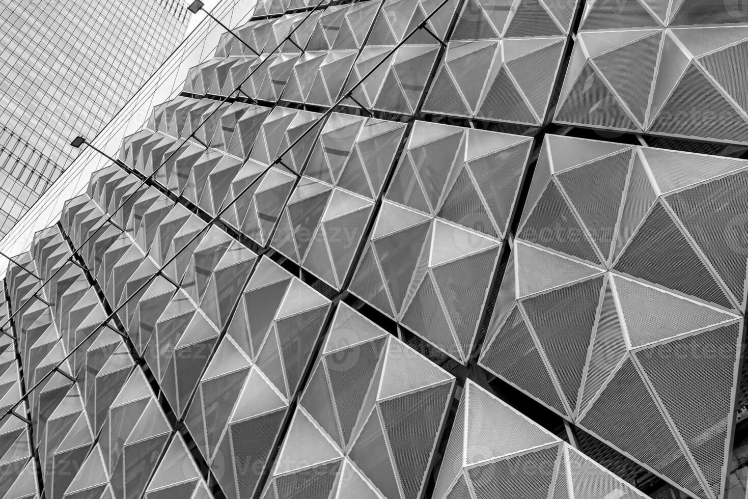 Fragment of a modern building. Abstract geometric background. Part of the facade of a skyscraper with metal diamond-shaped grids. photo