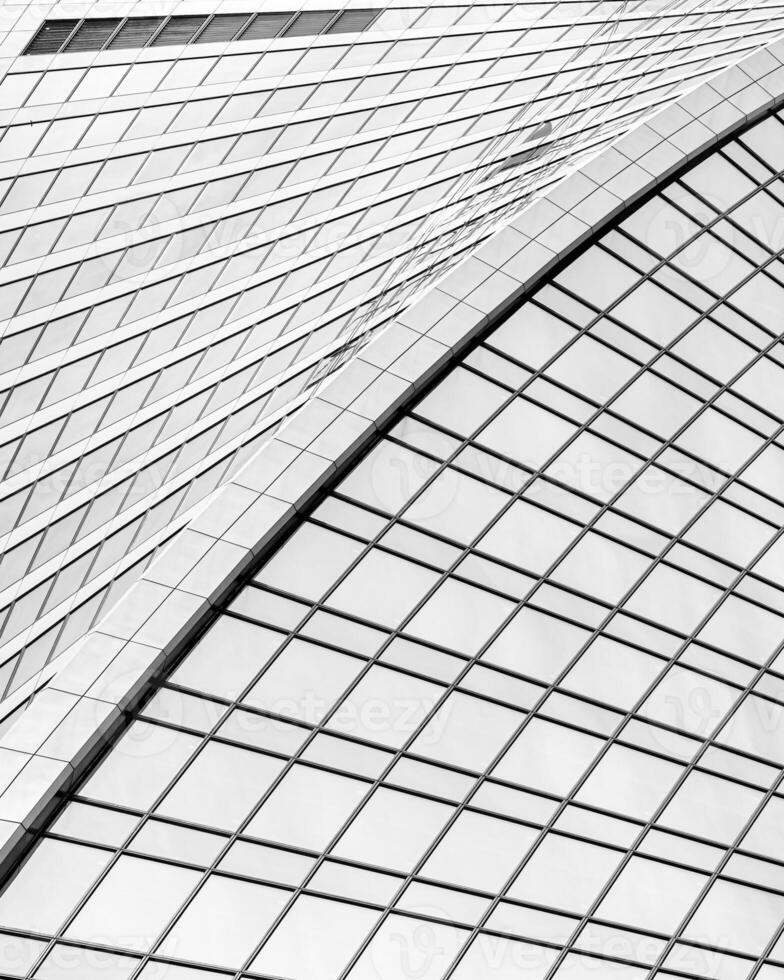 Fragment of a modern office building. Abstract geometric background. Part of a skyscraper with glass windows. Black and white. photo
