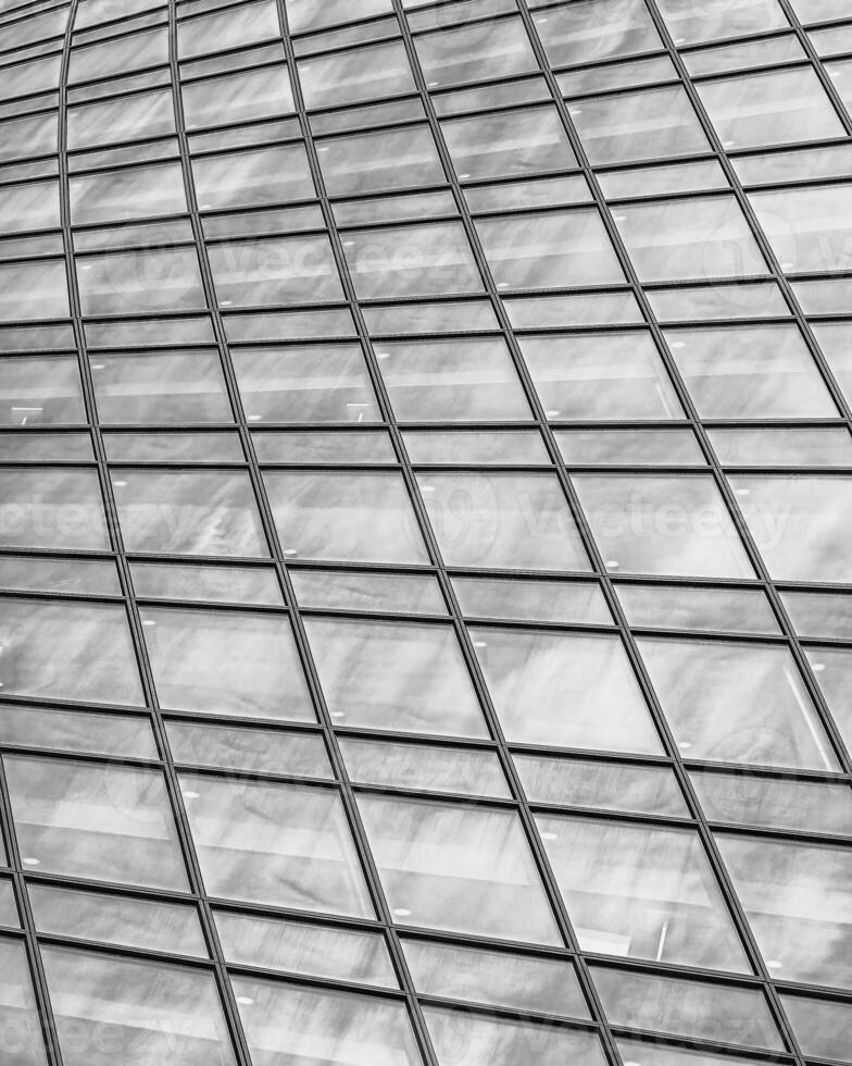 Fragment of a modern office building. Abstract geometric background. Part of a skyscraper with glass windows. Black and white. photo