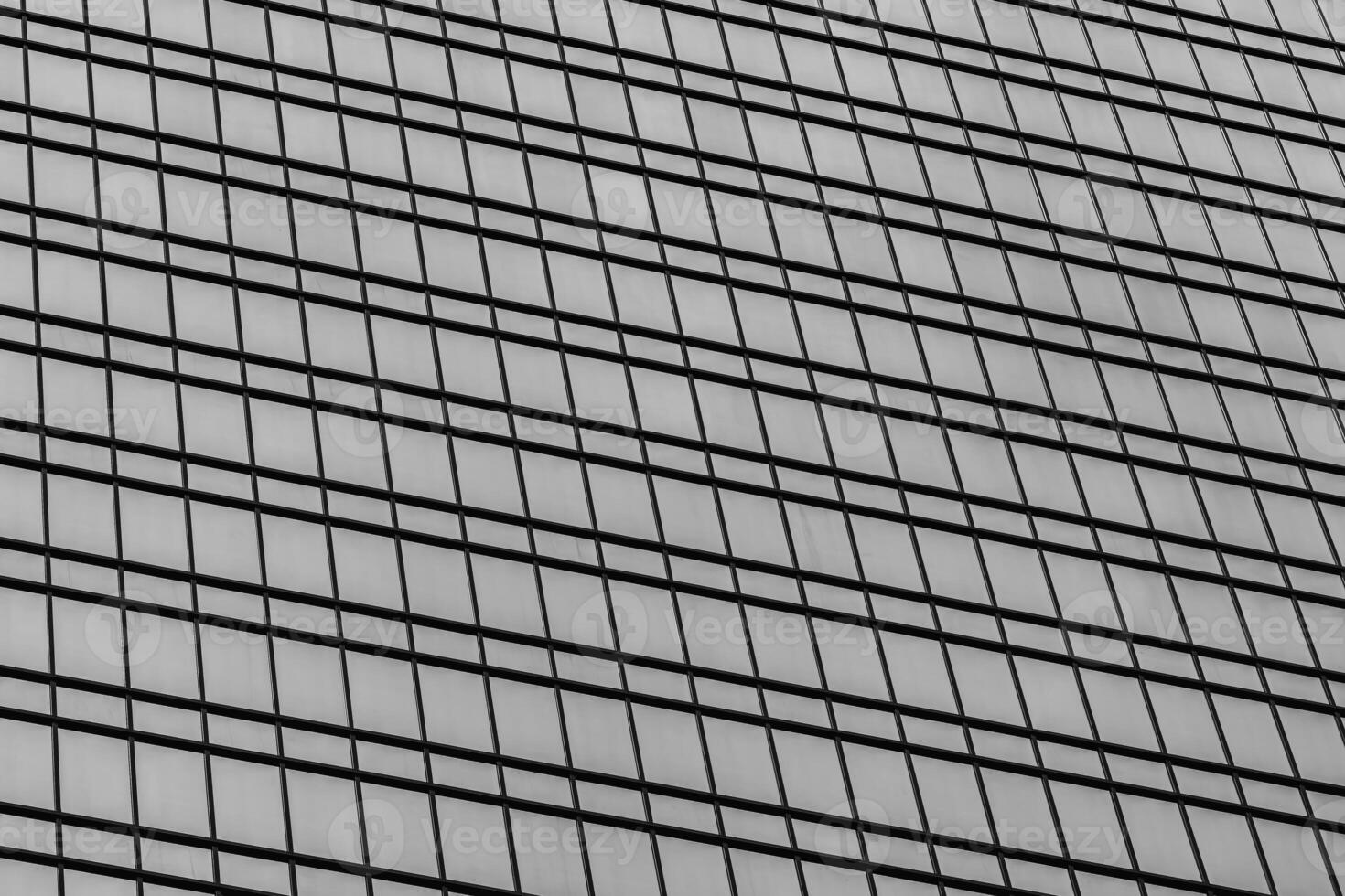 Fragment of a modern office building. Abstract geometric background. Part of a skyscraper with glass windows. Black and white. photo