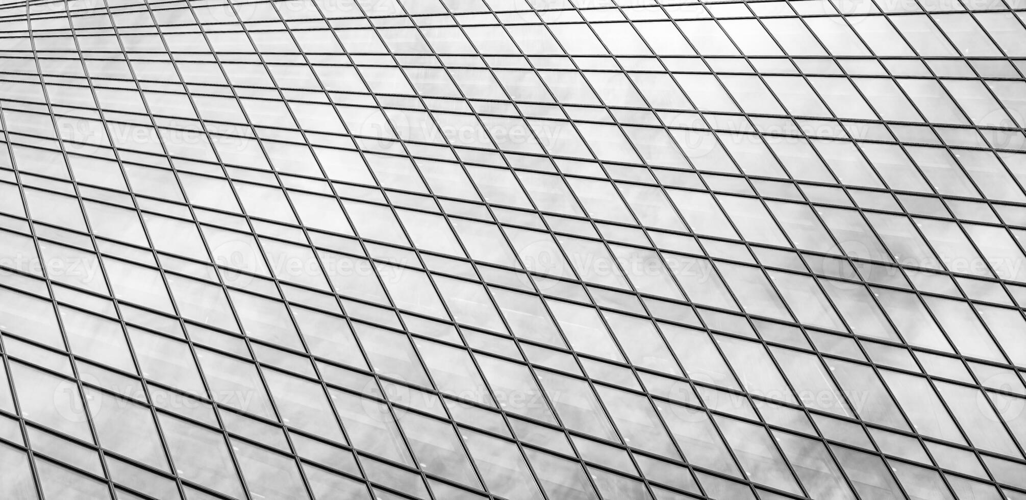 Fragment of a modern office building. Abstract geometric background. Part of a skyscraper with glass windows. Black and white. photo