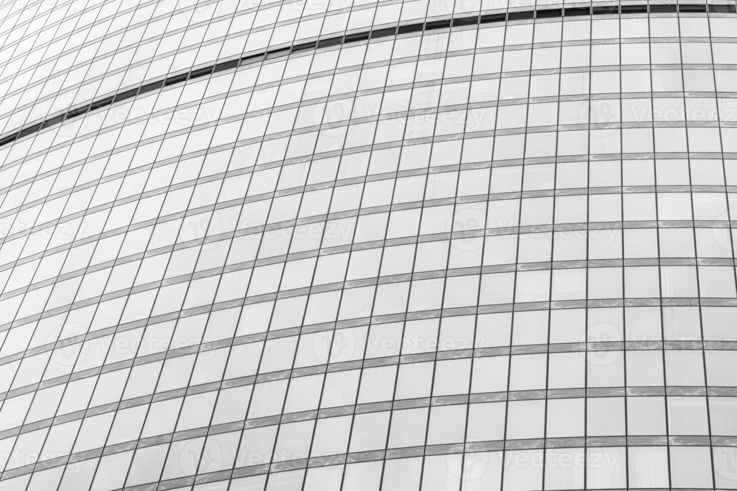 Fragment of a modern office building. Abstract geometric background. Part of a skyscraper with glass windows. Black and white. photo