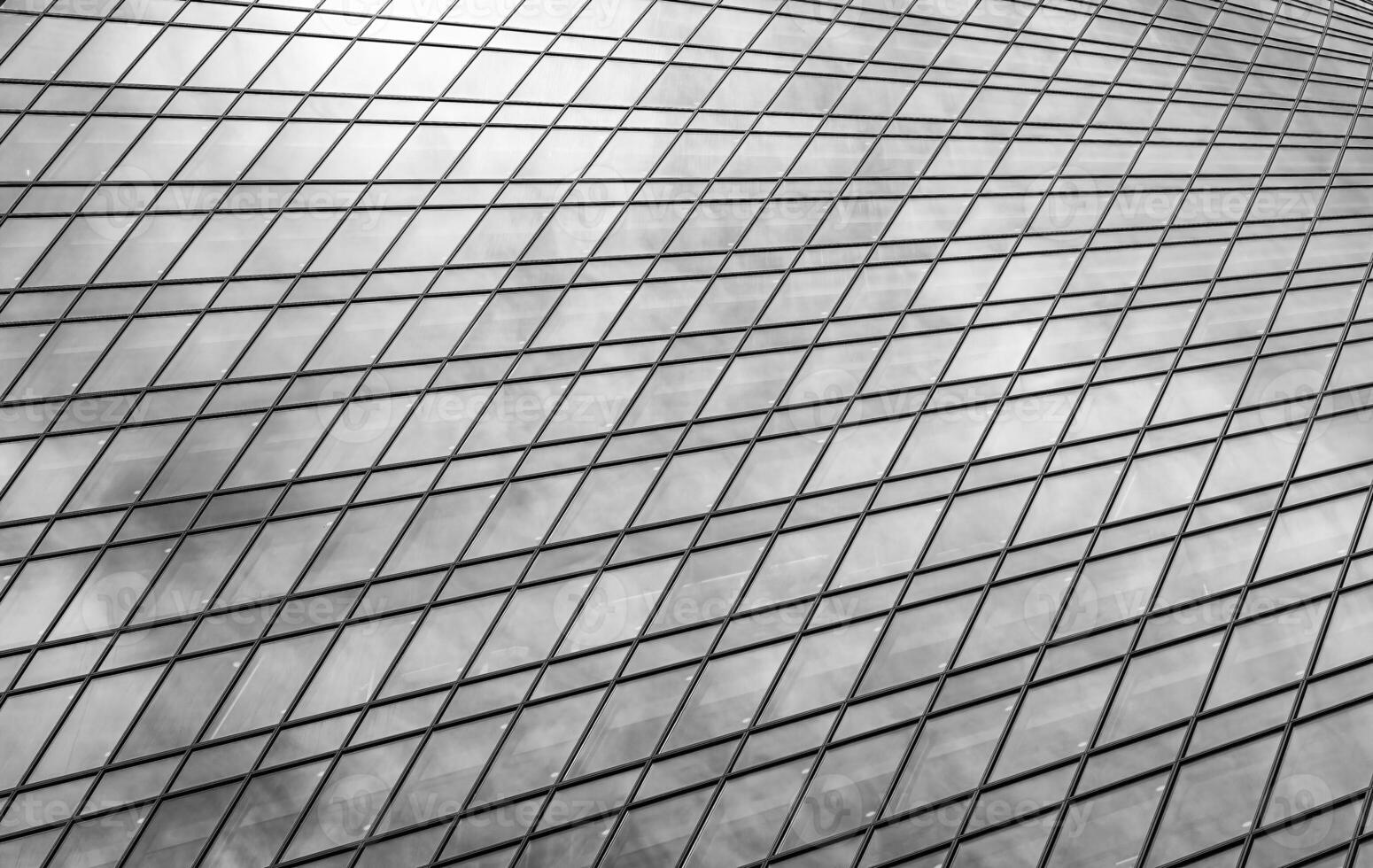 Fragment of a modern office building. Abstract geometric background. Part of a skyscraper with glass windows. Black and white. photo